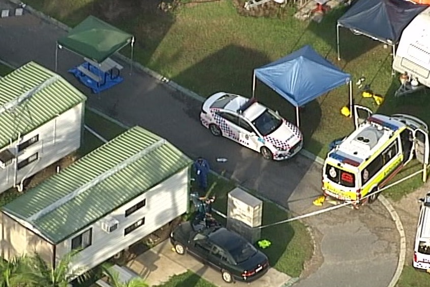 Aerial footage of cabins, and police and ambulance vehicles at the scene.