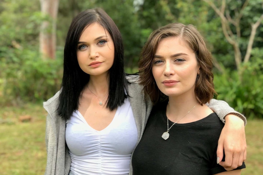 Morgan (l) and Ariel Taylor (r) standing for a photo with their arms around each other