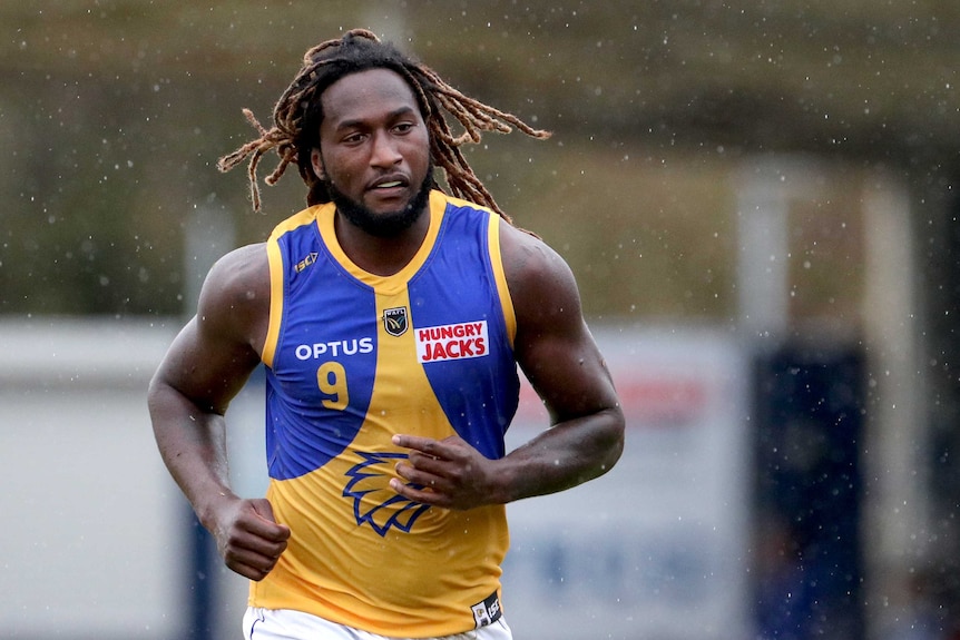 A mid shot showing West Coast Eagles ruckman Nic Naitanui running in the rain during a WAFL game.
