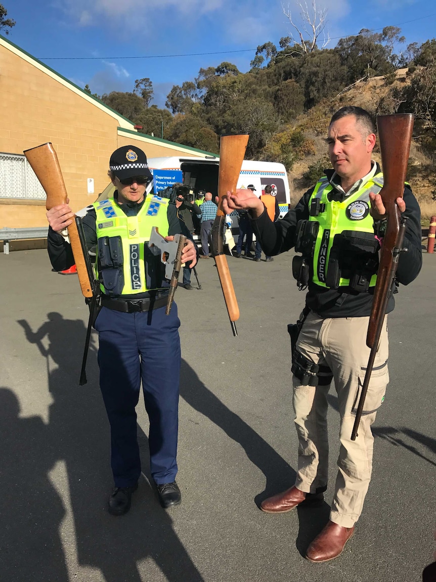 Police holding surrendered guns.