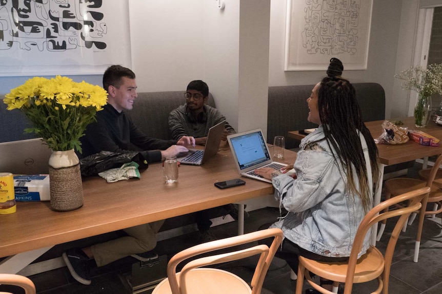 Boarding house tenants sit around a table