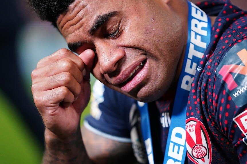 Kevin Naiqama wipes a tear from his eye while wearing his player of the match medal