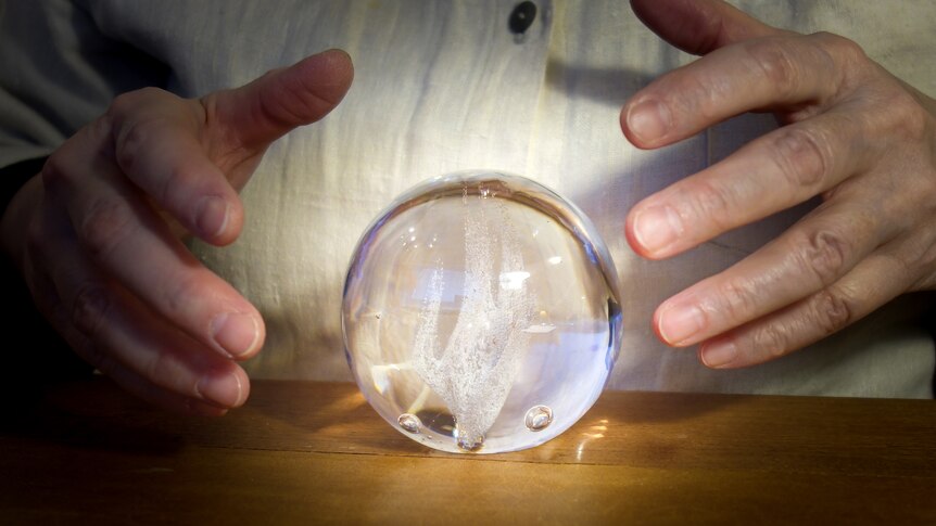 A staged mock set-up of a person divining answers from a crystal ball.