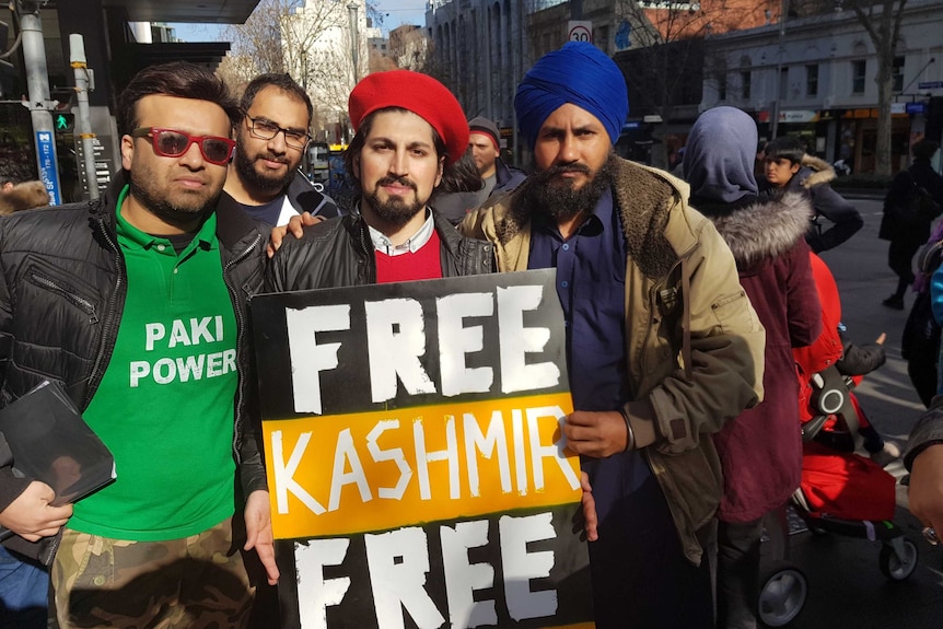 Four men hold a sign saying Free Kashmir