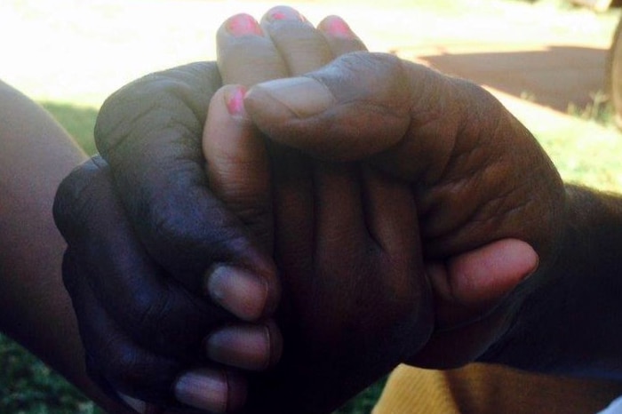 A mother holds her child's hand in hers at Newman, in WA