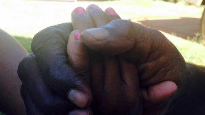 A mother holds her child's hand in hers at Newman, in WA