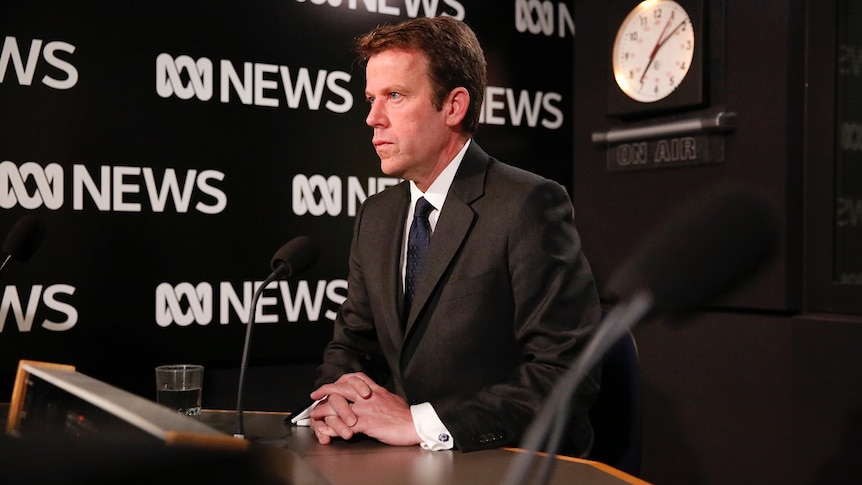 Dan Tehan sits in an ABC radio studio looking tense.