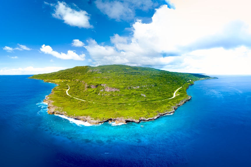 A bird's-eye photo of a small island on a clear day.