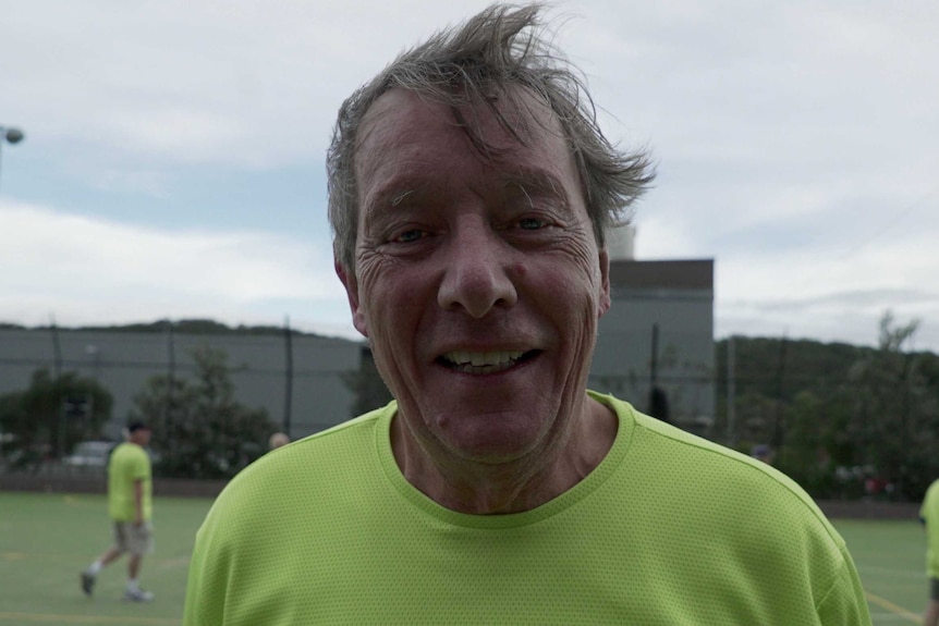 Walking football player Philip Taylor smiles at the camera.