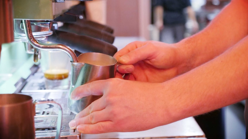 A close-up of a barista using a coffee machine
