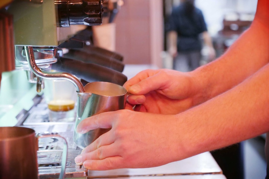 A close-up of a barista using a coffee machine