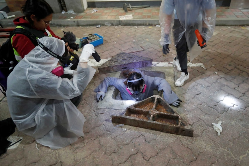 A protester tries to escape from a sewage tunnel inside the Hong Kong Polytechnic University campus during protests.