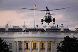 Marine One helicopter hovers near the White House at night