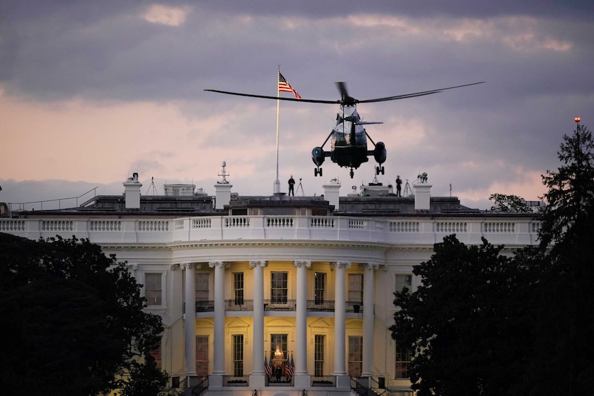 Marine One helicopter hovers near the White House at night