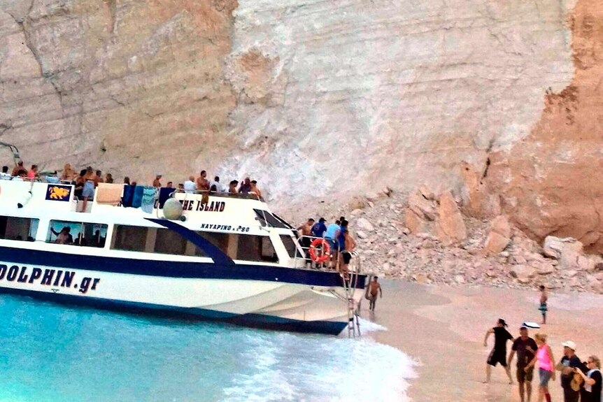 People disembark a boat after a landslide at a beach in Greece.