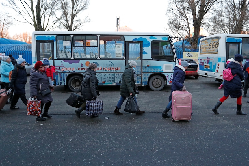 People walk with bags.