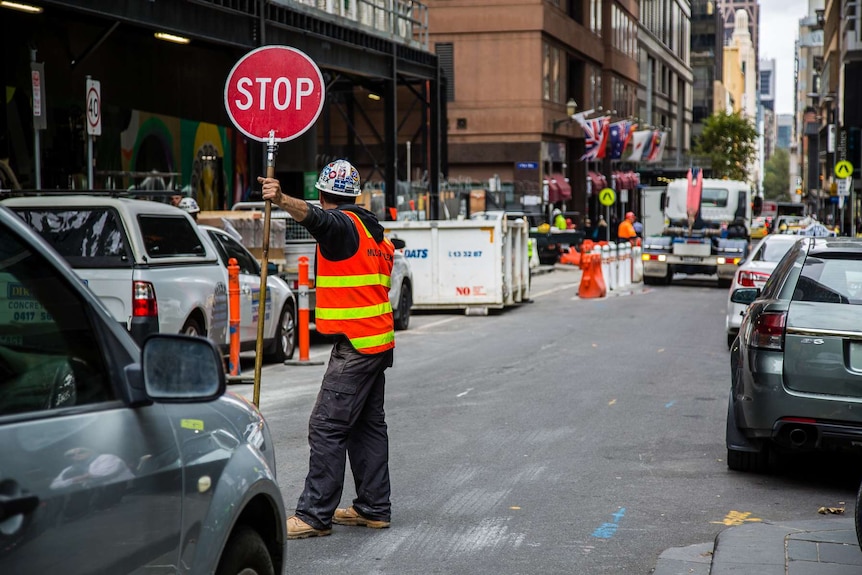 A construction worker holds a stop sign in Melbourne's CBD