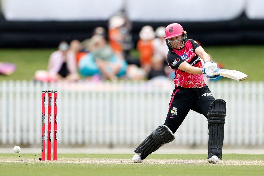 A Sydney Sixers WBBL player hits a cut shot square on the off side as the ball races away.