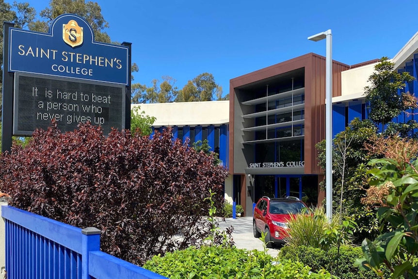 A sign out the front of a modern looking building reading "Saint Stephen's College", with a motto written beneath it.