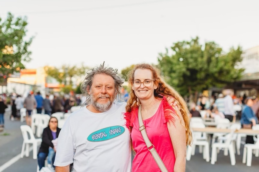 Jason and Tania Baldock stand with arms around each other, at the town's street fair.