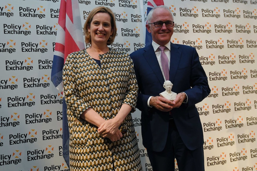 Malcolm Turnbull holds the Disraeli Award while posing for a photograph with British Home Secretary Amber Rudd.