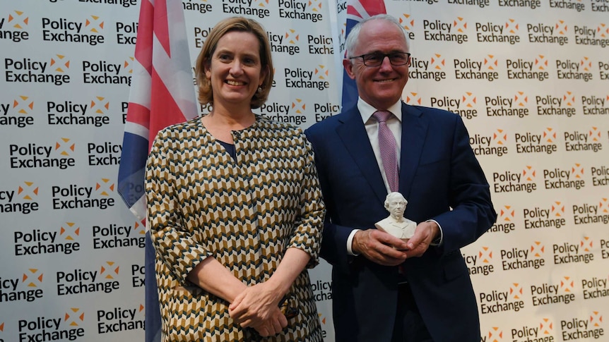 Malcolm Turnbull holds the Disraeli Award while posing for a photograph with British Home Secretary Amber Rudd.