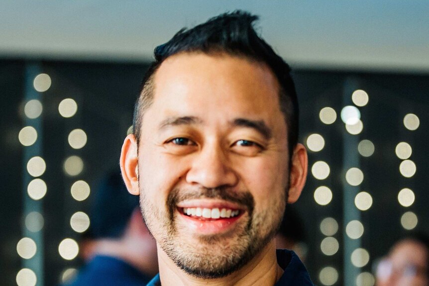 portrait of asian man in blue shirt smiling