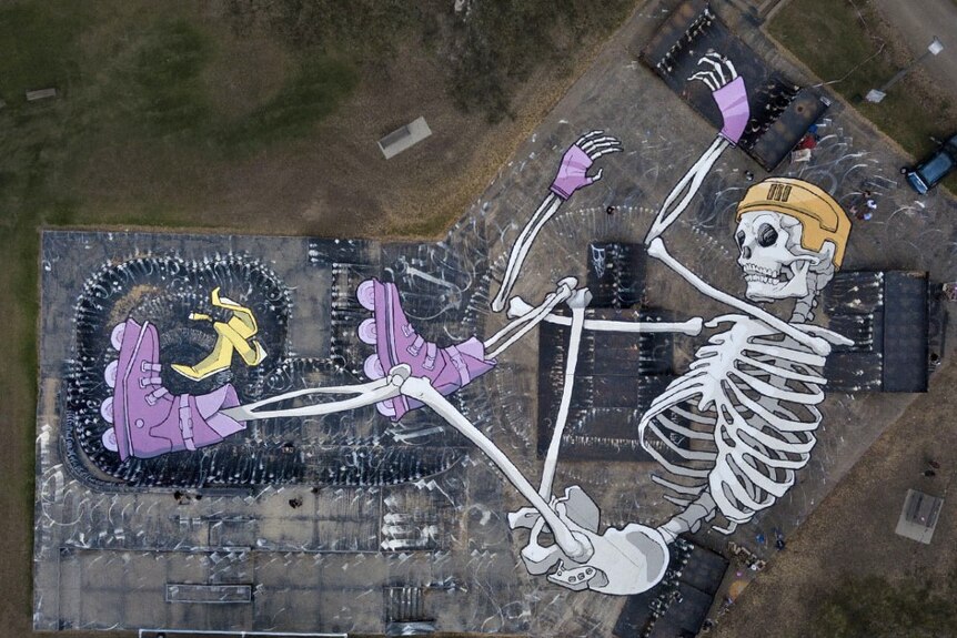A aerial photo depicting a mural of a skeleton in skating gear on the Benalla skatepark by artist Kitt Bennett.