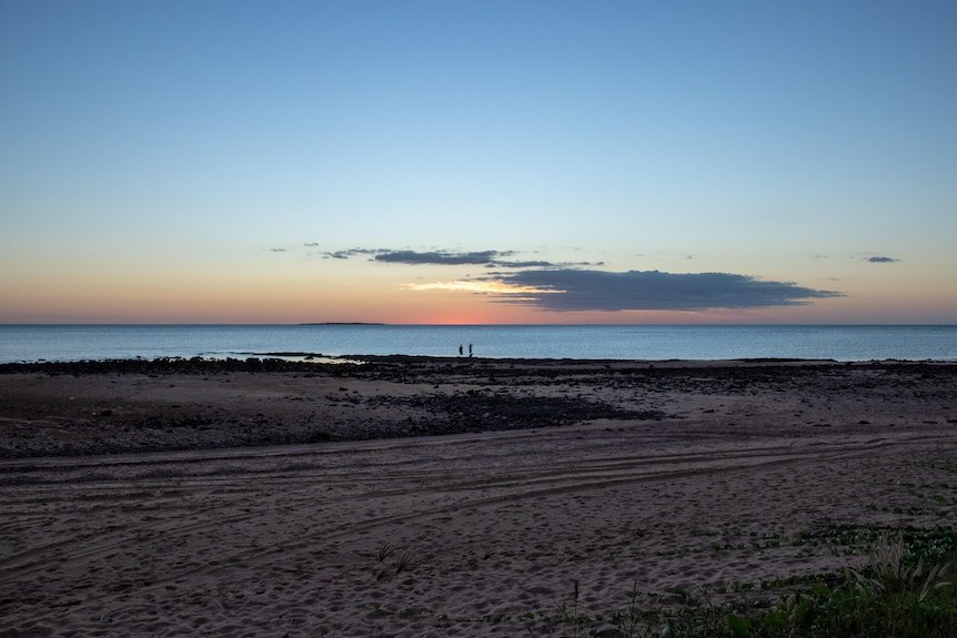 A beautiful sunset can be seen over a remote beach.