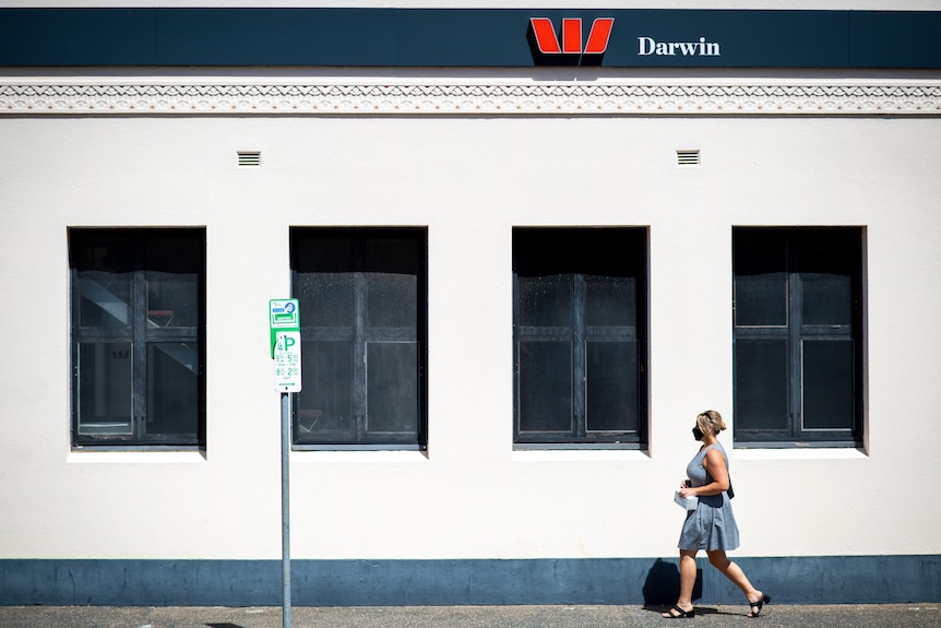 a woman walking in front of a bank