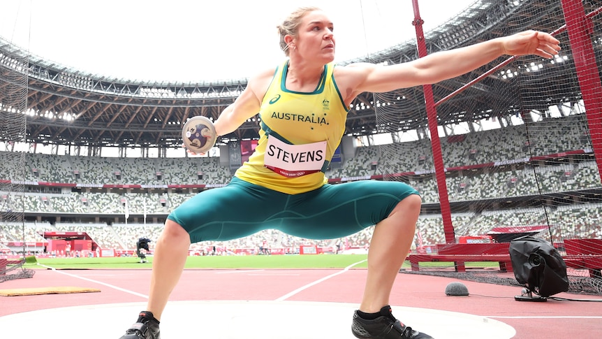 Dani Stevens squats as she prepares to throw her discus into the field