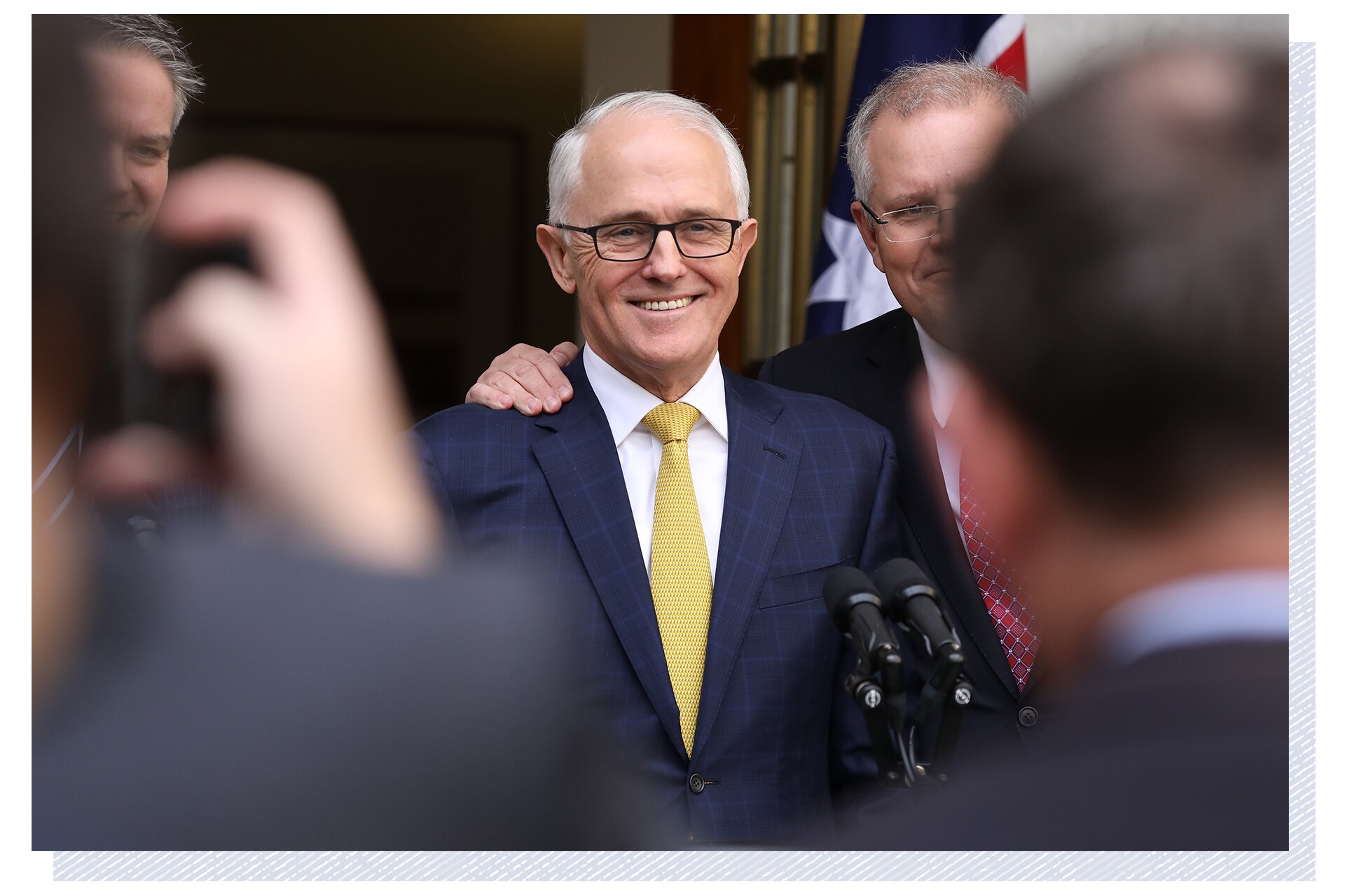 Three men at a press conference.