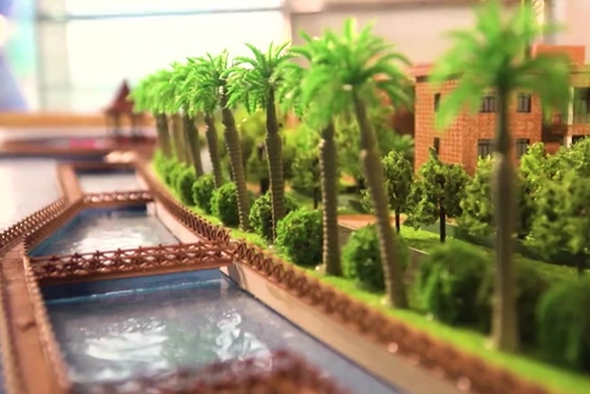 A closeup of model palm trees and a man-made canal.
