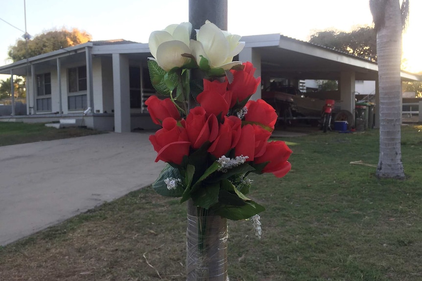 Flowers outside the Alva Beach home where a few days earlier two men were fatally stabbed.