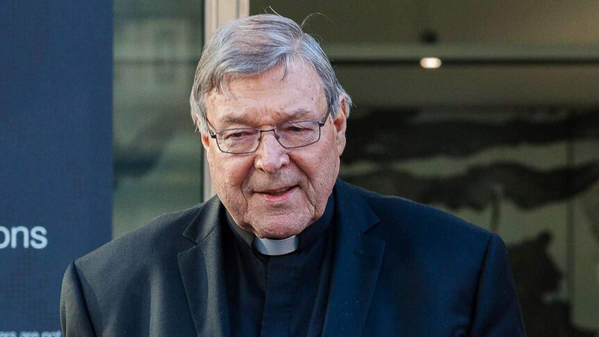 George Pell walks outside court.