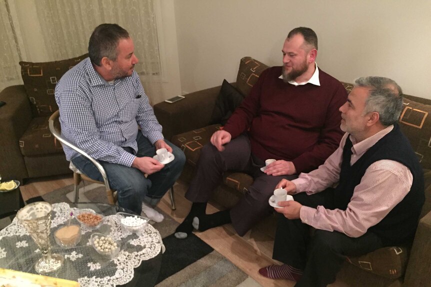 Islamic Council of Victoria executive director Nail Aykan sits in lounge room with friends Almir Colan (L) and Kazim Ates.
