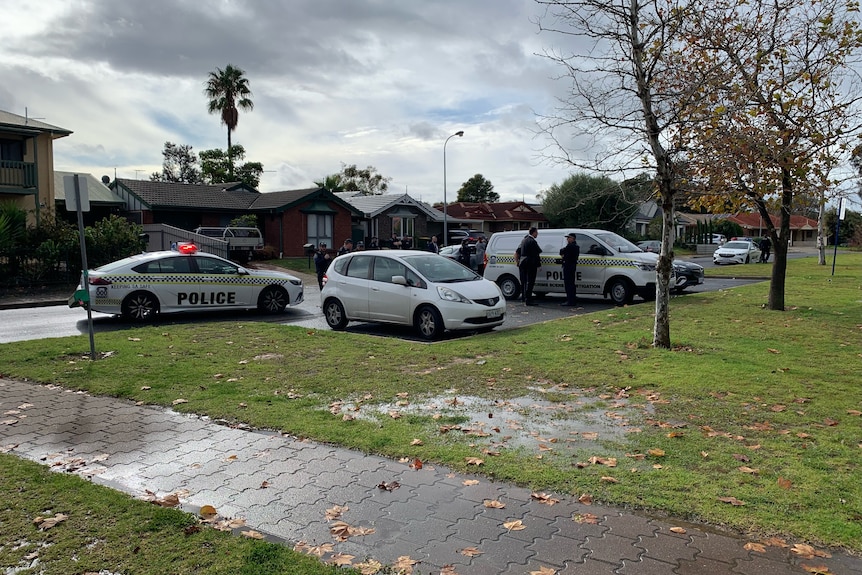 A hatchback with police vehicles around it