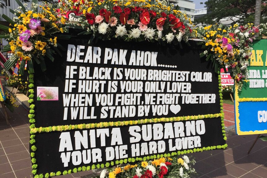 A black and white sign reads: "Dear pak ahok if black is your brightest colour, if hurt is your only lover...i will stand by you