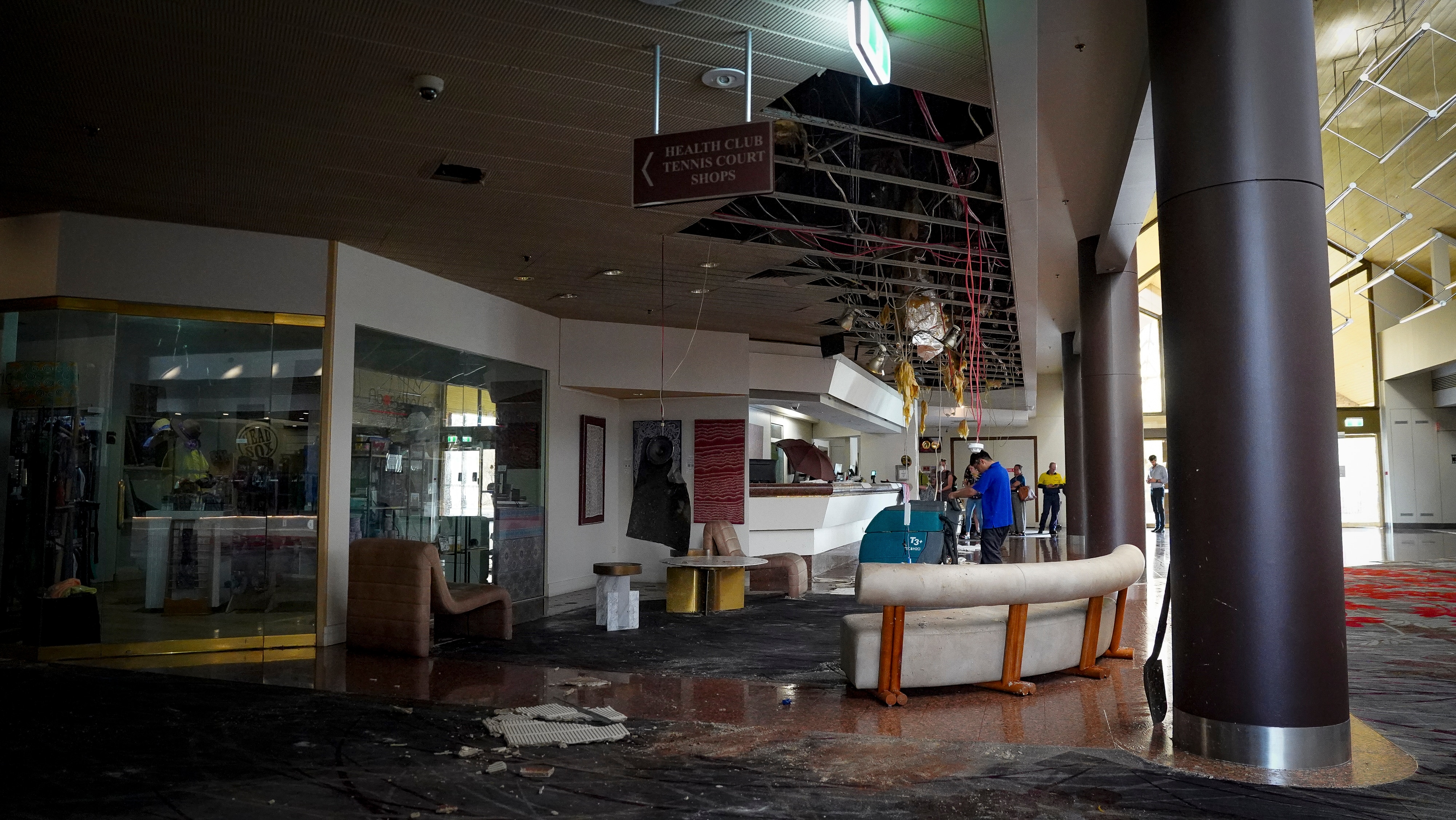 inside of hotel lobby with ceiling tiles smashed on wet floor