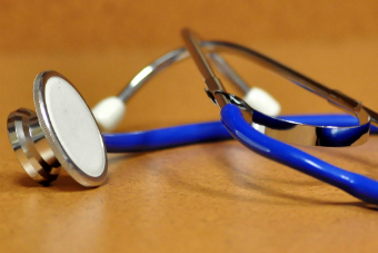 A stethoscope lying on a shiny surface.