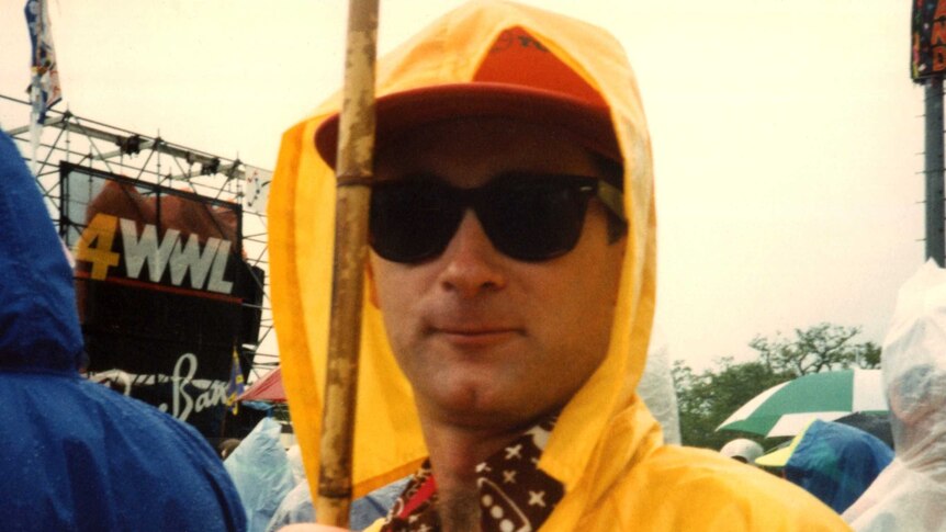 Dave Faulkner in a yellow rain jacket and sunglasses at jazzfest