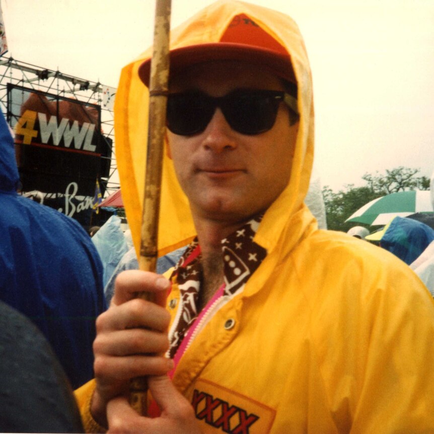 Dave Faulkner in a yellow rain jacket and sunglasses at jazzfest