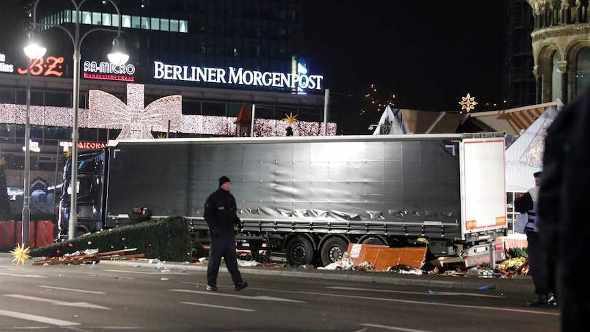 Police walk past truck at Berlin market