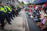 A line of police butt up against hundreds of protesters at Kangaroo Point.