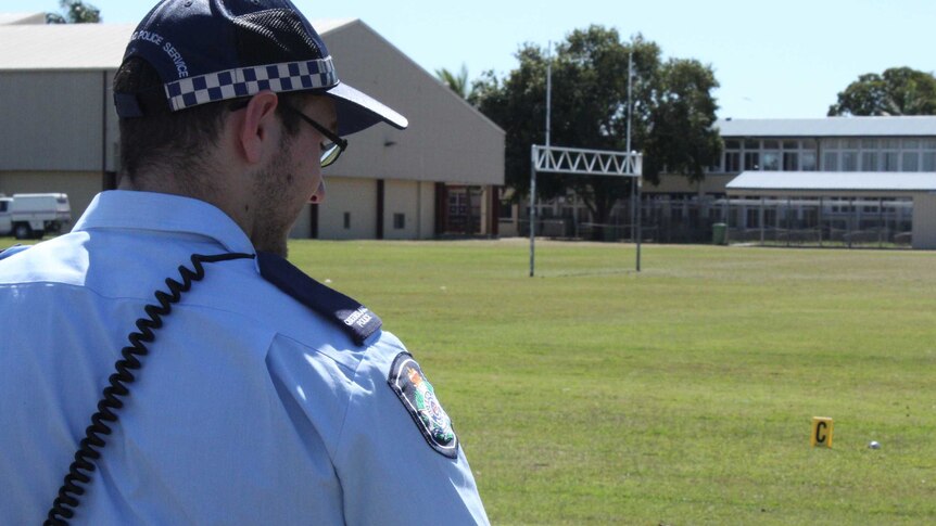 Police on patrol at Mackay State High School oval after the discovery of homemade bombs.