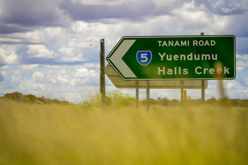 A road sign signalling the turn off to the Tanami Road, with Yuendumu and Halls Creek signposted