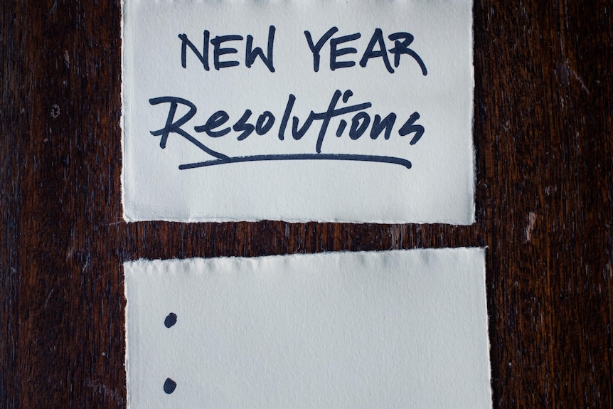 Note pad an pen with blank list of new year resolutions