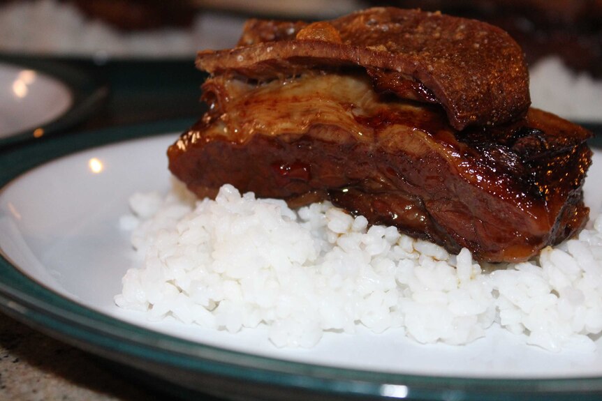 A piece of cooked brisket on rice.