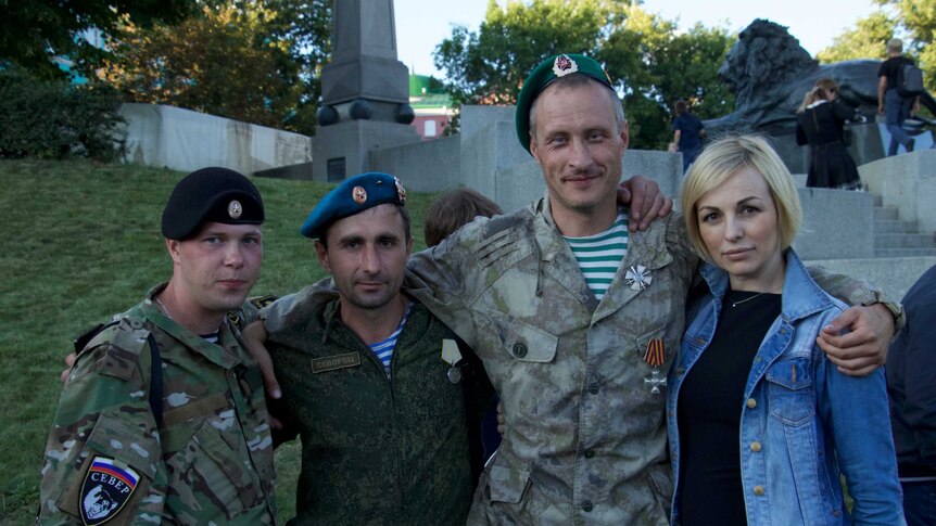 Russian soldiers returned from fighting in Ukraine's Donbas region congratulate each other