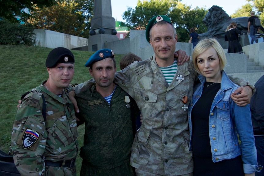 Russian soldiers returned from fighting in Ukraine's Donbas region congratulate each other